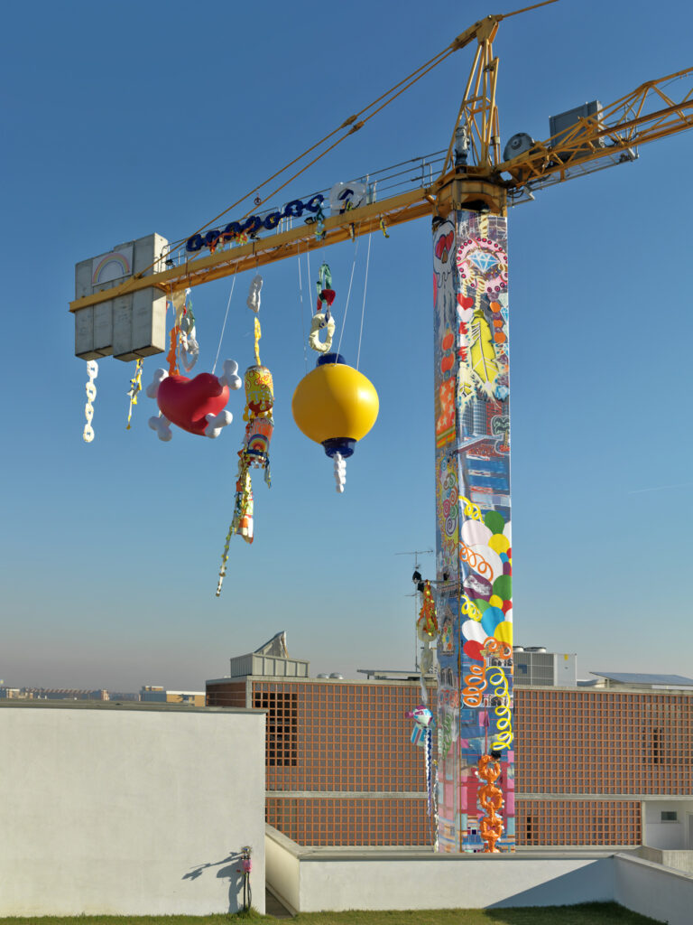 Chili Moon Town Tour Productions(Anna Galtarossa & Daniel González), Homeless Rocket With Chandeliers, 2007 Steel crane covered with printed vinyl, neon, lights, fabric, sequins, acrylic paint, 30 x 50 x 1,20 m installation view at Via Massimiano 25, Milan Courtesy the artists and Imperatore, Photo Andrea Martiradonna