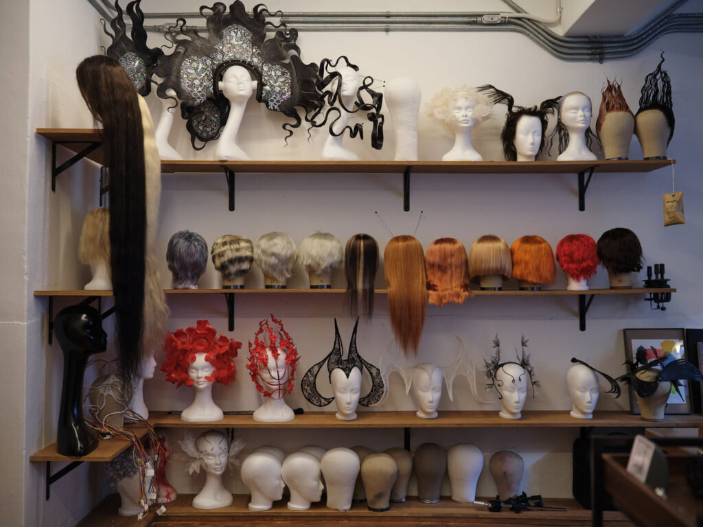 A view of the artist’s studio with various hairpieces.
