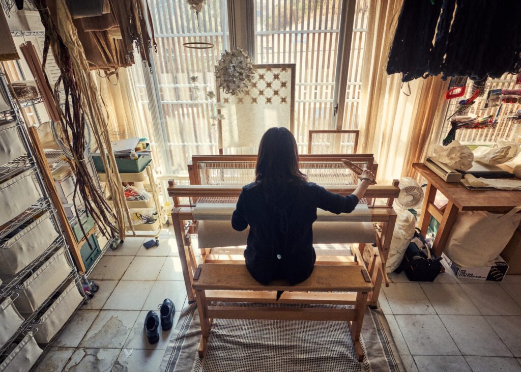 In the artist’s hands, paper becomes fiber, then the foundation for weaving and crochet work.